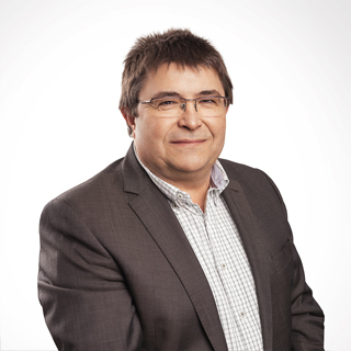 Porträt eines Mannes mit freundlichem Lächeln und kompetenter Ausstrahlung.